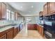 Spacious kitchen with wood cabinets, granite countertops, stainless steel appliances, and hardwood flooring at 16021 Verbena St, Brighton, CO 80602