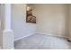 Spacious living room with plush carpet, a staircase with a dark wood banister, and neutral walls at 16021 Verbena St, Brighton, CO 80602