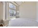 Open-concept living room featuring high ceilings, ample natural light, and neutral carpet at 16021 Verbena St, Brighton, CO 80602