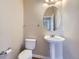 Charming powder room with pedestal sink, round mirror, and stylish fixtures at 16021 Verbena St, Brighton, CO 80602