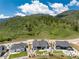 Aerial view of a modern home, showcasing its well-manicured lawn, fire pit area, and mountain views at 5225 Mesa Top Dr, Monument, CO 80132