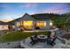 Beautiful backyard with a stone fire pit and seating area, a covered patio, and a well-manicured lawn at 5225 Mesa Top Dr, Monument, CO 80132