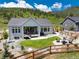 Aerial view of backyard featuring a stone fire pit with seating and a covered patio with outdoor furniture at 5225 Mesa Top Dr, Monument, CO 80132