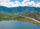 Scenic view of a lake and surrounding community, featuring mountains in the background and a walking path alongside the water at 5225 Mesa Top Dr, Monument, CO 80132