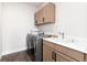 Modern laundry room featuring light wood cabinets, a gray washer and dryer and light-colored walls at 5225 Mesa Top Dr, Monument, CO 80132