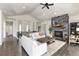 Open-concept living room featuring a stone fireplace, vaulted ceilings, hardwood floors, and an adjacent staircase at 5225 Mesa Top Dr, Monument, CO 80132