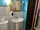 Clean bathroom with pedestal sink, tiled walls, and built-in storage at 571 Geneva St, Aurora, CO 80010