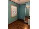 Bedroom with hardwood floors, teal walls, and window at 571 Geneva St, Aurora, CO 80010