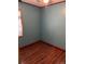 Small bedroom with light blue walls and wood-look flooring at 571 Geneva St, Aurora, CO 80010