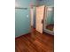 Bedroom with hardwood floors, teal walls, and mirrored closet at 571 Geneva St, Aurora, CO 80010