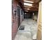 Unfinished carport with concrete floor and brick exterior wall at 571 Geneva St, Aurora, CO 80010
