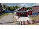 Charming brick house with a red and white picket fence and a spacious parking area at 571 Geneva St, Aurora, CO 80010