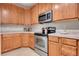 Well-lit kitchen featuring stainless steel appliances, light countertops, and light wood cabinets at 3852 S Dallas St # 8-102, Aurora, CO 80014
