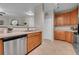 Bright kitchen with wood cabinets, stainless steel dishwasher and double sink, with a view to the living area at 3852 S Dallas St # 8-102, Aurora, CO 80014