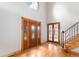 Bright foyer with hardwood floors, a large front door and a staircase leading upstairs at 102 Staghorn Way, Franktown, CO 80116