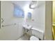 Compact half-bathroom featuring a sink, toilet, and window for natural light at 6579 S Lincoln St, Centennial, CO 80121