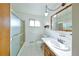 Bright bathroom with a tiled floor, framed mirror, and shower with glass doors and updated lighting at 6579 S Lincoln St, Centennial, CO 80121