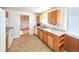 Functional kitchen with wood cabinets, a double sink, and an adjoining dining area at 6579 S Lincoln St, Centennial, CO 80121