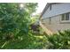 Side yard featuring lush greenery, a brick wall, and side access to the property at 6579 S Lincoln St, Centennial, CO 80121