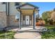 Portico entrance features a covered porch, front door with glass detail, and brick accents at 6500 E Asbury Ave, Denver, CO 80224