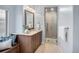 Elegant bathroom with a granite countertop vanity and a glass-enclosed shower with custom tiling at 9715 E 33Rd Ave, Denver, CO 80238
