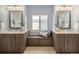 Luxurious bathroom featuring dual vanities, a built-in bench, and plenty of storage space at 9715 E 33Rd Ave, Denver, CO 80238