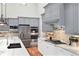 Modern kitchen featuring gray cabinets, stainless steel appliances, marble countertops and gas range at 9715 E 33Rd Ave, Denver, CO 80238