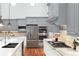 Kitchen with stainless appliances, a gas cooktop and oven, marble countertops and gray cabinets at 9715 E 33Rd Ave, Denver, CO 80238