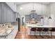Bright, open kitchen with gray cabinets, marble countertops, stainless appliances, and wood floors at 9715 E 33Rd Ave, Denver, CO 80238