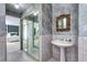A traditional bathroom features a pedestal sink, a walk-in closet with mirrored doors, and muted walls at 561 Saulsbury St, Lakewood, CO 80226