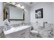 This bathroom has a modern sink and vanity, marble tiled wall, and an ornate mirror at 561 Saulsbury St, Lakewood, CO 80226