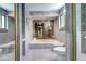 A full shot of an ornate bathroom with a sunken tub, tiled walls, and a mirrored wall to the left at 561 Saulsbury St, Lakewood, CO 80226