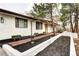 Charming white brick home with brick walkway, planter beds and beautiful mature trees at 561 Saulsbury St, Lakewood, CO 80226
