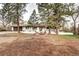 Inviting white brick exterior featuring a manicured front yard with mature trees and seating area at 561 Saulsbury St, Lakewood, CO 80226
