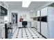 Modern kitchen featuring white cabinets, stainless steel appliances, and a black and white tiled floor at 561 Saulsbury St, Lakewood, CO 80226