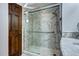 The shower with glass doors features marble tiled walls, a rainfall shower head, and a bench at 561 Saulsbury St, Lakewood, CO 80226