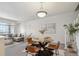 Open-concept dining area with modern chandelier, glass table, and stairway access at 12711 Colorado Blvd # H804, Thornton, CO 80241