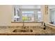 Kitchen with granite countertops and stainless steel sink features open view to the living area at 12711 Colorado Blvd # H804, Thornton, CO 80241