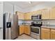 Well-lit kitchen features stainless steel appliances, granite countertops, and light wood cabinets at 12711 Colorado Blvd # H804, Thornton, CO 80241