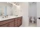 Modern bathroom with double sinks, wood cabinets and separate toilet room at 20588 E 63Rd Ave, Aurora, CO 80019