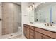 Contemporary bathroom with double vanity, tiled shower with glass door, and modern fixtures at 20588 E 63Rd Ave, Aurora, CO 80019