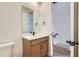 Bathroom featuring a wood vanity, white countertop, and a framed mirror at 20588 E 63Rd Ave, Aurora, CO 80019