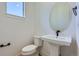 Powder room featuring pedestal sink, oval mirror, and toilet with neutral colored walls at 20588 E 63Rd Ave, Aurora, CO 80019
