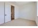 Bright bedroom with neutral carpet, white walls, and a closet entrance with white door at 20588 E 63Rd Ave, Aurora, CO 80019