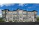 Beautiful townhome with stone and modern gray siding, paired windows and individual front balconies at 20588 E 63Rd Ave, Aurora, CO 80019