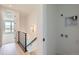 Hallway leading to a sunlit room with metal railing with the laundry connections nearby at 20588 E 63Rd Ave, Aurora, CO 80019