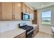 Modern kitchen with stainless steel appliances, wooden cabinetry, and bright countertops at 20588 E 63Rd Ave, Aurora, CO 80019
