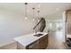 Bright kitchen featuring large island with a sink and modern lighting fixtures at 20588 E 63Rd Ave, Aurora, CO 80019