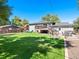 Expansive backyard featuring a wooden deck, patio, green lawn, and a play area at 6684 S Buffalo Dr, Littleton, CO 80120