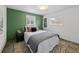 Comfortable bedroom featuring an accent wall, plush bedding, and natural light from two windows at 6684 S Buffalo Dr, Littleton, CO 80120